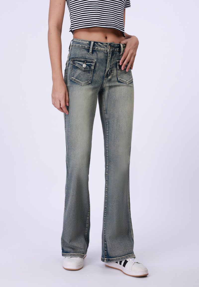 Flared jeans in lichtblauwe denim met een vervaagde afwerking. Kenmerken zijn onder andere vijf zakken, een knoopsluiting en een minimalistisch ontwerp.
