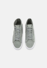 Paire de baskets montantes Vans grises avec lacets et semelles blanches en caoutchouc, vues de dessus sur fond blanc.