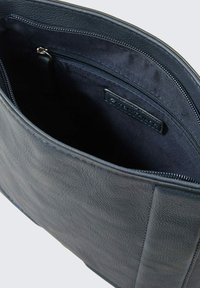 Granatowa skórzana torba z teksturowanym wykończeniem, z zamknięciem na górze na zamek błyskawiczny oraz miękkim podszyciem. Zawiera wewnętrzną kieszeń dla lepszej organizacji.