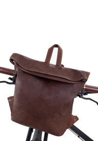 Brown leather backpack with a rolled top, zipper closure, side accents, and stitching details, designed to attach to a bicycle handlebar.