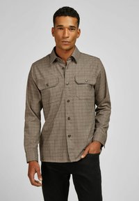 Geruit button-up overhemd in bruin en crème. Bevat twee borstzakken, een kraag en lange mouwen. Gemaakt van textielmateriaal.