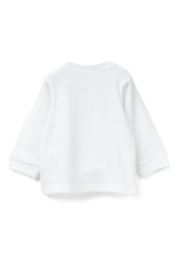 Bílé tričko s dlouhým rukávem, kulatým výstřihem, manžetami na rukávech a hladkou, čistou texturou. Bez výrazných vzorů nebo ozdob.