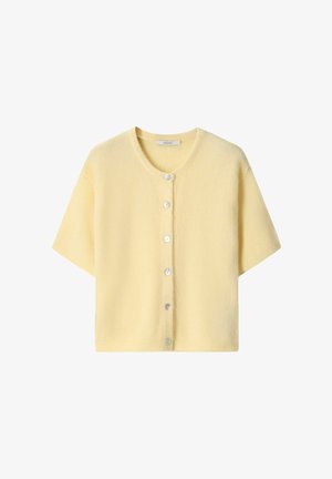 Cardigan en maille jaune pâle à manches courtes avec encolure ronde et six boutons blancs sur le devant, étalé à plat sur un fond blanc.