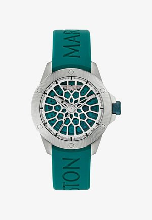 Aston Martin Uhr mit einem Gehäuse aus silbernem Edelstahl, einem türkisfarbenen Gummiarmband und einem komplexen Ziffernblatt mit Netzmuster, Ziffern und sichtbarem Logo.