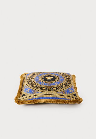 Zils dekoratīvs spilvens ar zelta un melniem grezniem rakstiem, ar bārkstīm apmalē un centrālu emblēmas dizainu. Mīkstas auduma tekstūra.