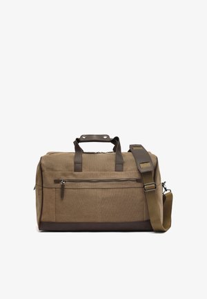 Brown canvas duffel bag with leather handles, front zip pocket, and adjustable shoulder strap with padded section.