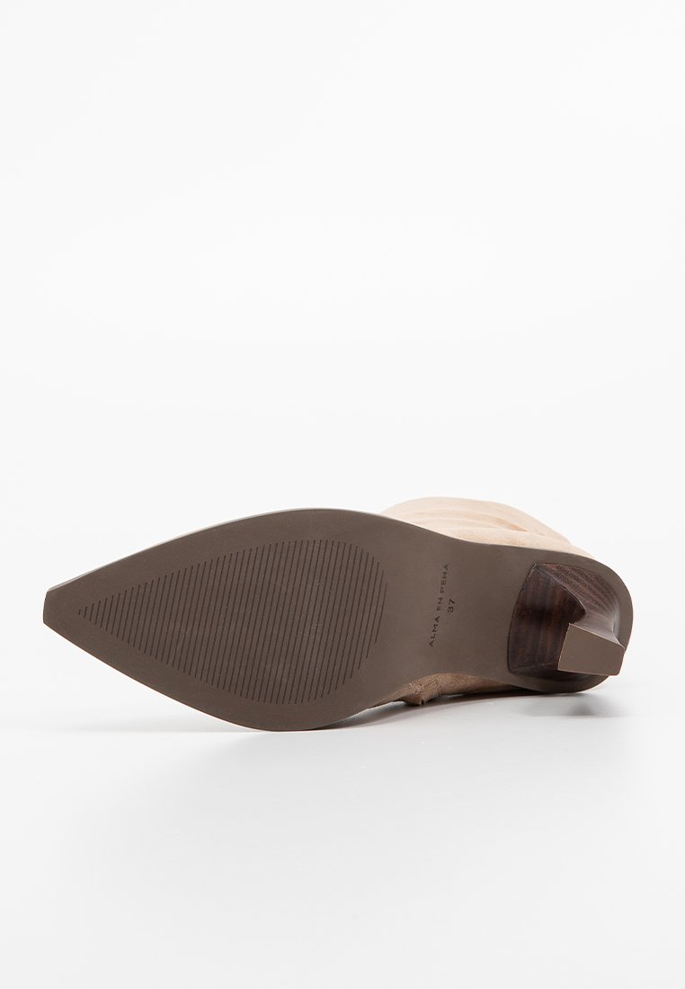 Bota de ante beige con puntera afilada, suela de goma texturizada y tacón de madera rectangular, tamaño 37, tumbada de lado mostrando la suela.