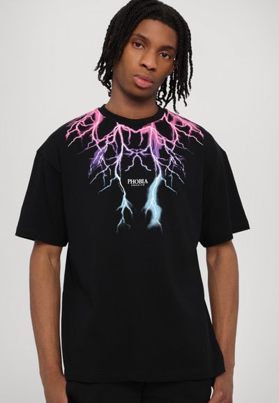 T-shirt nera a maniche corte con una grafica audace di un fulmine in rosa, viola e blu, centrata sopra la parola "FOBIA". Materiale in cotone morbido.