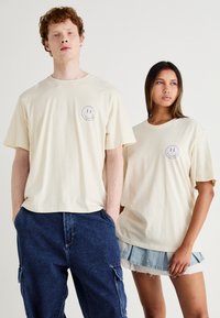 Jack & Jones JORREALMEAL TEE UNISEX - T-shirts med print - buttercream