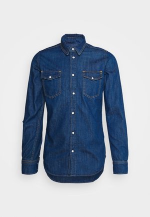 Donkerblauw denimshirt met lange mouwen, knoopsluiting aan de voorkant, twee borstzakken, puntige kraag en lichte contrasterende stiksels.