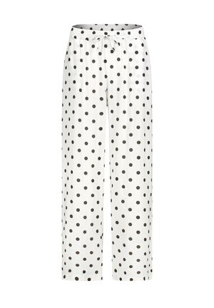 White loose pants with black polka dots and an elastic waistband featuring a front tie drawstring.