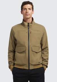 Bruine, ritssluiting jack met een hoge kraag, twee borstzakken en gestructureerde manchetten. Glad materiaal met een minimalistisch ontwerp en geen zichtbare logo's.