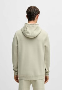 Felpa con cappuccio color beige chiaro, dallo spessore texturizzato e dalla vestibilità comoda. Dotata di maniche sportive e fondo confezionato liscio.