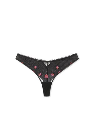 Perizoma in pizzo nero con ricami floreali in rosa. Presenta pannelli trasparenti, bordature ondulate e una cintura in tessuto morbido.