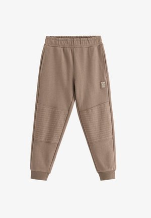 Brune joggebukser med elastisk talje, ribstrikkede manchetter, quiltede knælapper, sidelommer og et "PLAY ALL DAY" mærke på højre lår.