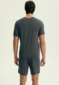 Szary t-shirt z krótkim rękawem i dopasowane szorty wykonane z gładkiego, lekkiego materiału, z klasycznym okrągłym dekoltem i luźnym krojem.