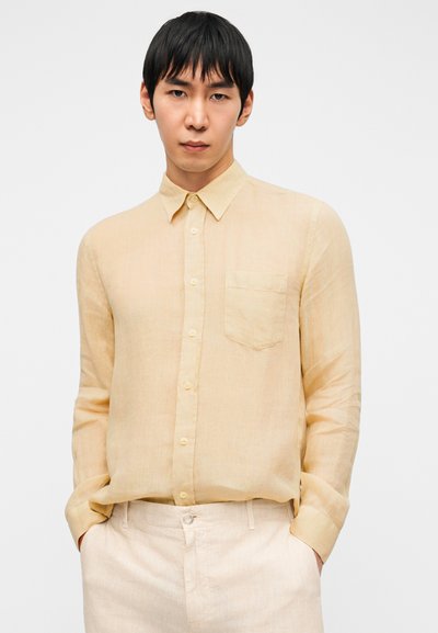 Ανοιχτό κίτρινο πουκάμισο μακρυμάνικο από λινό με κουμπιά μπροστά, μία τσέπη στο στήθος και κλασικό γιακά. Ομαλή υφή, άνετη εφαρμογή.