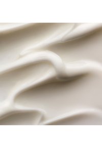 Myk, flytende hvit krem med glanset tekstur og myke folder, jevnt smurt over en flat overflate.