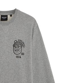 Felpa grigia con un design grafico nero che rappresenta un volto con un cappello, testo che recita "HIGHLANDER" e "1874", e dettagli del colletto a costine.