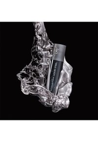 Schwarze und silberne Flasche mit dem Etikett "Sebastian Liquid Steel", umhüllt von flüssigem Metall, zeigt eine elegante zylindrische Form mit einem matten Deckel.