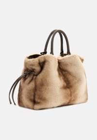 Borsa in pelliccia sintetica di colore marrone chiaro con una texture morbida. Presenta due manici in pelle marrone scuro e un design con cima arricciata.