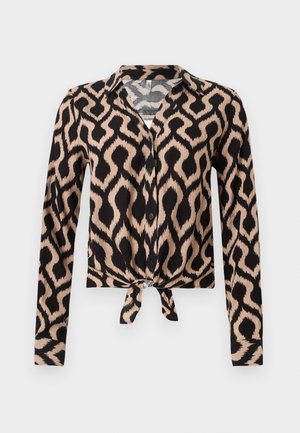 Blouse à manches longues boutonnée avec col, motif géométrique abstrait noir et beige, et détail noué à l'avant à la taille.