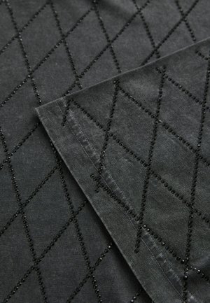 Țesătură neagră cu un model în diamant, embellisată cu mici mărgele negre de-a lungul cusăturilor, evidențiind o suprafață texturată și detaliată.