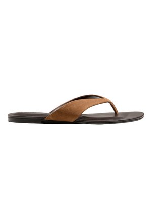 Sandale en daim marron avec semelle plate noire, vue de côté sur fond blanc.