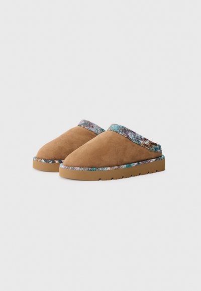 Bruna mockaskinns slip-on skor med ett texturerat, flerfärgat band vid kragen och en robust gummisula.