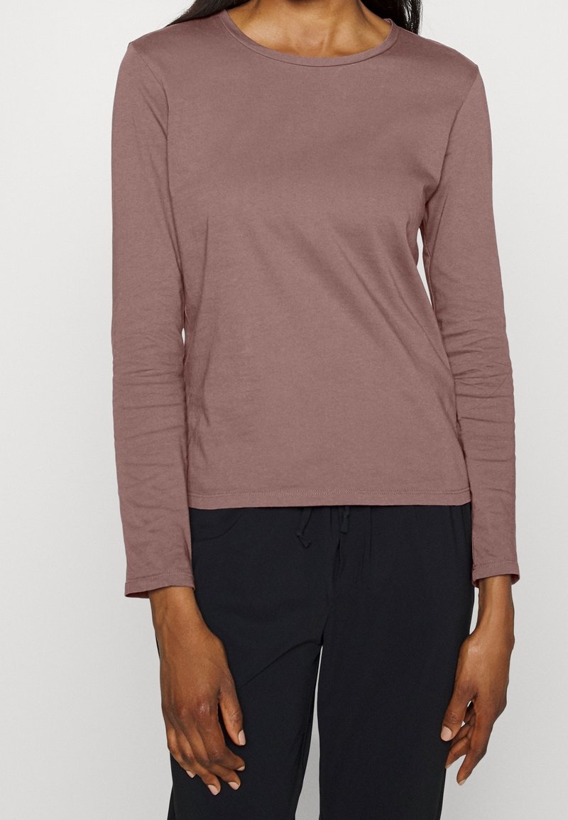 Långärmad, rundhalsad skjorta i mauve, tillverkad av mjuk bomullsblandning. Lättviktig tyg med en bekväm passform och subtila sömdetaljer.