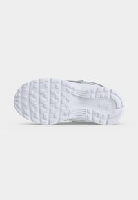 Λευκή λαστιχένια σόλα παπουτσιού Nike με διακοσμημένα πέλματα και το λογότυπο της Nike χαραγμένο κοντά στην περιοχή της πτέρνας.