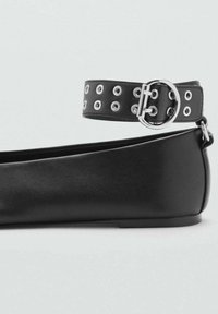 Ballerine nere con finitura in pelle liscia, dotate di una ampia fascia nera decorata con occhielli argentati e un dettaglio a fibbia rotonda.