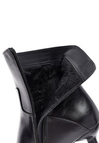 Stivale alla caviglia in pelle nera con una morbida fodera in pelliccia nera, design elegante e cerniera laterale per la chiusura. Presenta un tacco alto e una finitura liscia.