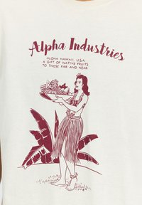 Kreemim colorist puuvillane T-särk, millel on marooni värvi graafika naisest, kes hoiab puuviljakorvi, ümbritsetud troopiliste lehtede ja dekoratiivse tekstiga.