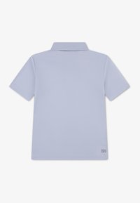 Ανοιχτό μπλε πόλο πουκάμισο με γιακά, κοντά μανίκια, ομαλή υφή και διακριτική ετικέτα "Ultra Dry" στο κάτω δεξί μέρος.