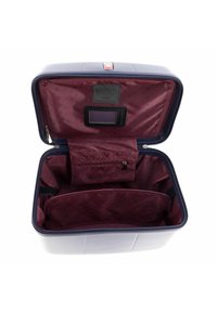 Maleta rígida de color azul marino, con un interior burdeos abierto, múltiples compartimentos y un bolsillo con cremallera para organizar.