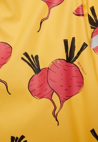 Geel stof met illustraties van rode bietjes, zwarte stelen en het woord "BIET" dicht bij een biet gedrukt.