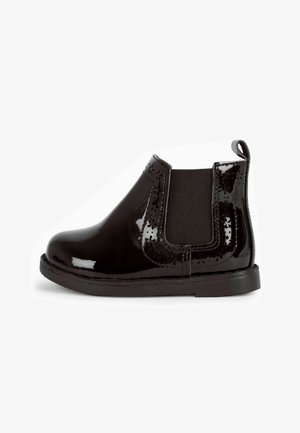 Zwarte patentleren Chelsea-boot met elastische zijpanelen, ronde neus, een trekband en een platte rubberen zool. Bevat details in een bloemenpatroon.
