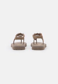 Brown flip-flop sandals with a textured strap, adorned with decorative beads. Flat soles with slight elevation at the heel.