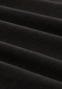 Tessuto nero con una texture liscia, che mostra morbide pieghe e un motivo tessuto uniforme, mettendo in risalto il suo colore omogeneo e la qualità del materiale.