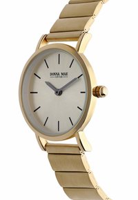Gold wristwatch with beige dial, black hour markers, two gray hands, and "Donna Mae New York" branding, attached to a linked metal band.