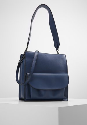 Donkerblauwe leren handtas met voorflapvak, twee schouderbanden en een gestructureerde rechthoekige vorm op een witte ondergrond.