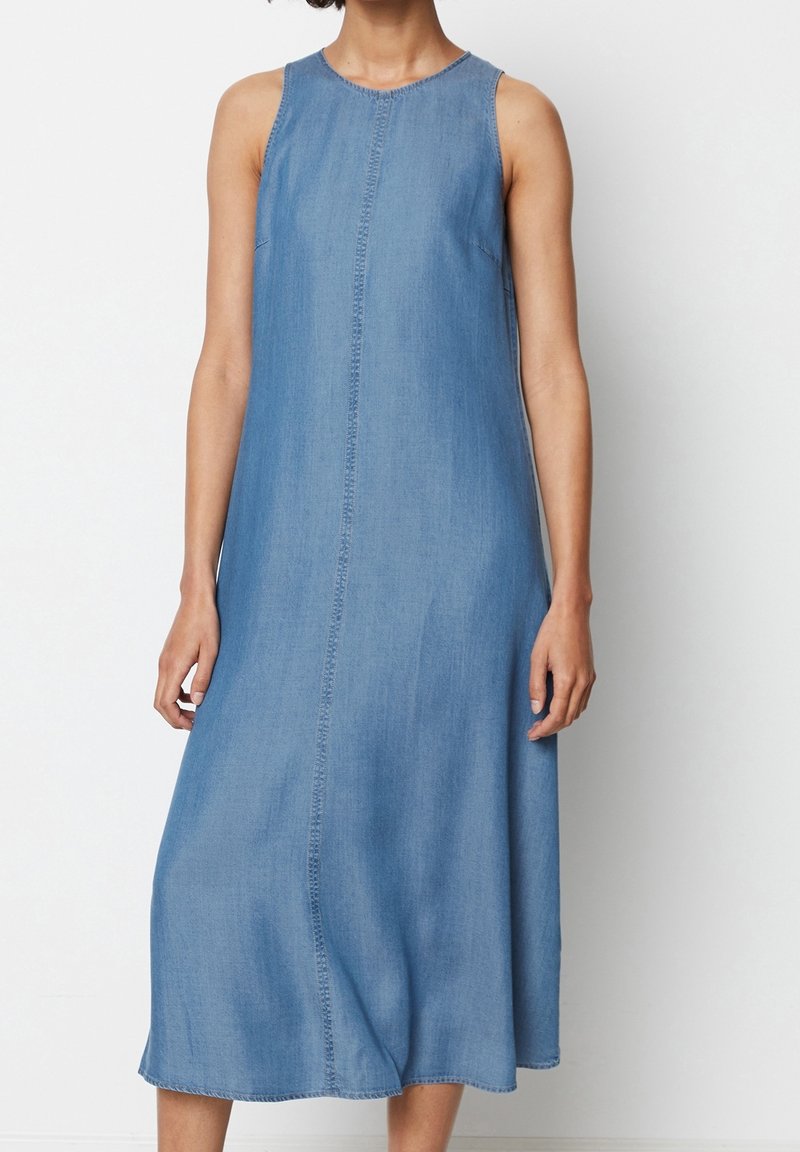 Vestido sin mangas de mezclilla azul con silueta recta, escote redondo y detalle de costura central. Llega hasta la mitad de la pantorrilla con una textura suave.