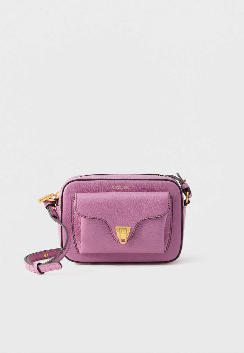 Leather crossbody bag in light purple with gold hardware, featuring a front pocket and adjustable strap. Smooth texture with a structured shape.