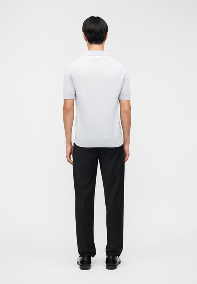 Világosszürke rövid ujjú pólóing, kötött anyagból, testhezálló szabású, bordázott gallérral és mandzsettával, fekete nadrággal és cipővel párosítva.