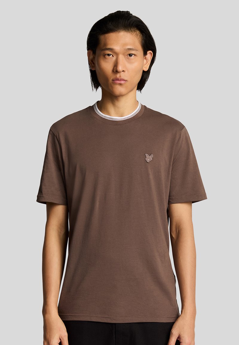 T-shirt in cotone marrone con maniche corte, scollatura rotonda a costine con dettagli bianchi e piccolo logo sul petto.