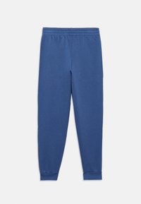 Μπλε βαμβακερές φόρμες με ελαστική μέση, στενά πόδια και ριμπ μανσέτες. Ομοιόμορφη υφή, χωρίς ορατά σχέδια ή διακοσμήσεις.