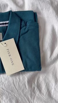Tefarbenes Poloshirt aus Baumwolle, mit Kragen und umgeschlagenen Ärmeln. Etikett mit "PIER: ONE" angebracht. Glatte Textur, klassisches Design.