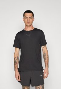 Sort kortærmet atletisk t-shirt med rund hals og hvid "HYROX" samt Puma-logo. Fremstillet af letvægtsstof, tilbyder en afslappet pasform.