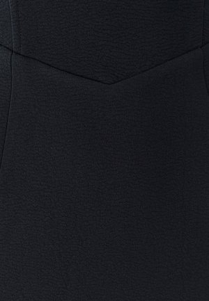 Tissu noir texturé avec une finition lisse, présentant une forme ajustée et des coutures angulaires. Pas de motifs visibles ni de détails matériels.